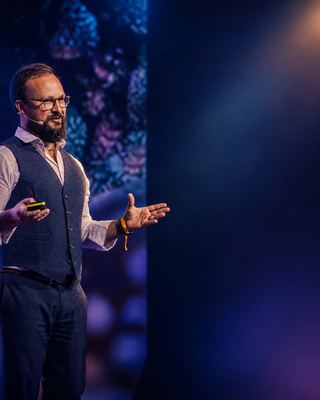 A speaker passionately engaging the audience during a session at the HOLOLIFE Summit 2026.