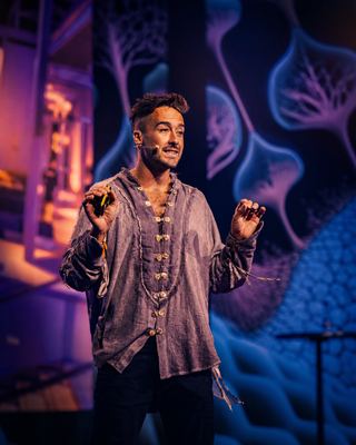 A speaker engaging the audience at the HOLOLIFE Summit, discussing innovations in wellness and biohacking.