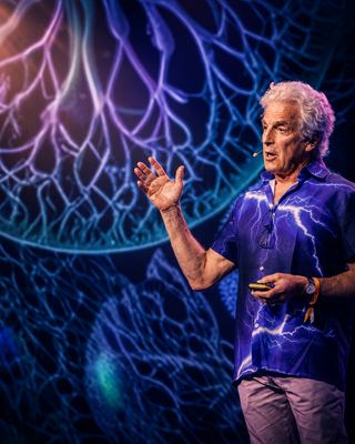 A speaker engages the audience with a dynamic presentation about wellness optimization at HOLOLIFE Summit 2026.
