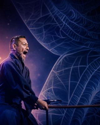 A dynamic speaker passionately engaging the audience on stage at the HOLOLIFE Summit.