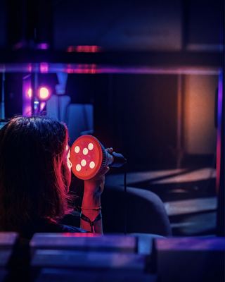 A participant engaging with biohacking technology at the HOLOLIFE Summit 2026 in Amsterdam.