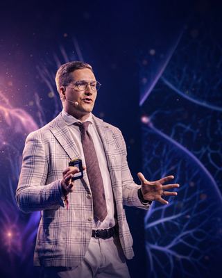 A speaker presents innovative concepts on stage at the HOLOLIFE Summit 2026.