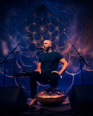 A performer engages the audience with a unique instrument during a session at the HOLOLIFE Summit 2026.