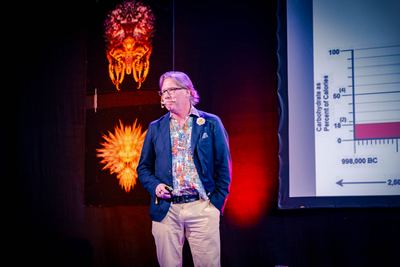 A speaker presents insights on longevity trends during the HOLOLIFE Summit 2025 in Tallinn.