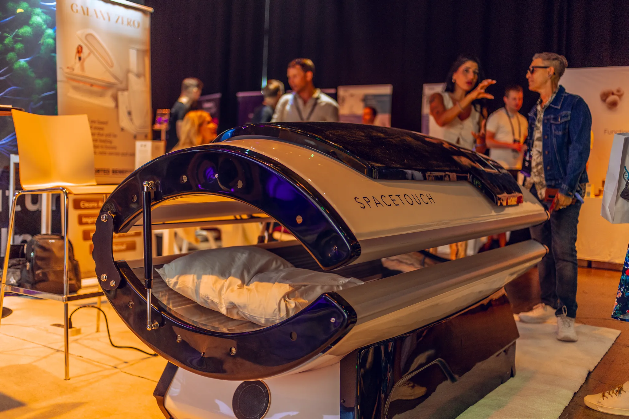 Attendees trying a wellness device on the exhibition floor at Biohacker Summit 2024