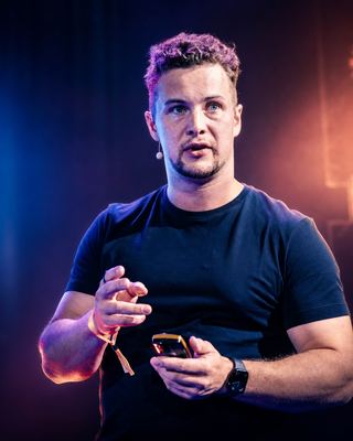 A speaker passionately engaging with the audience during a session at the HOLOLIFE Summit 2026.